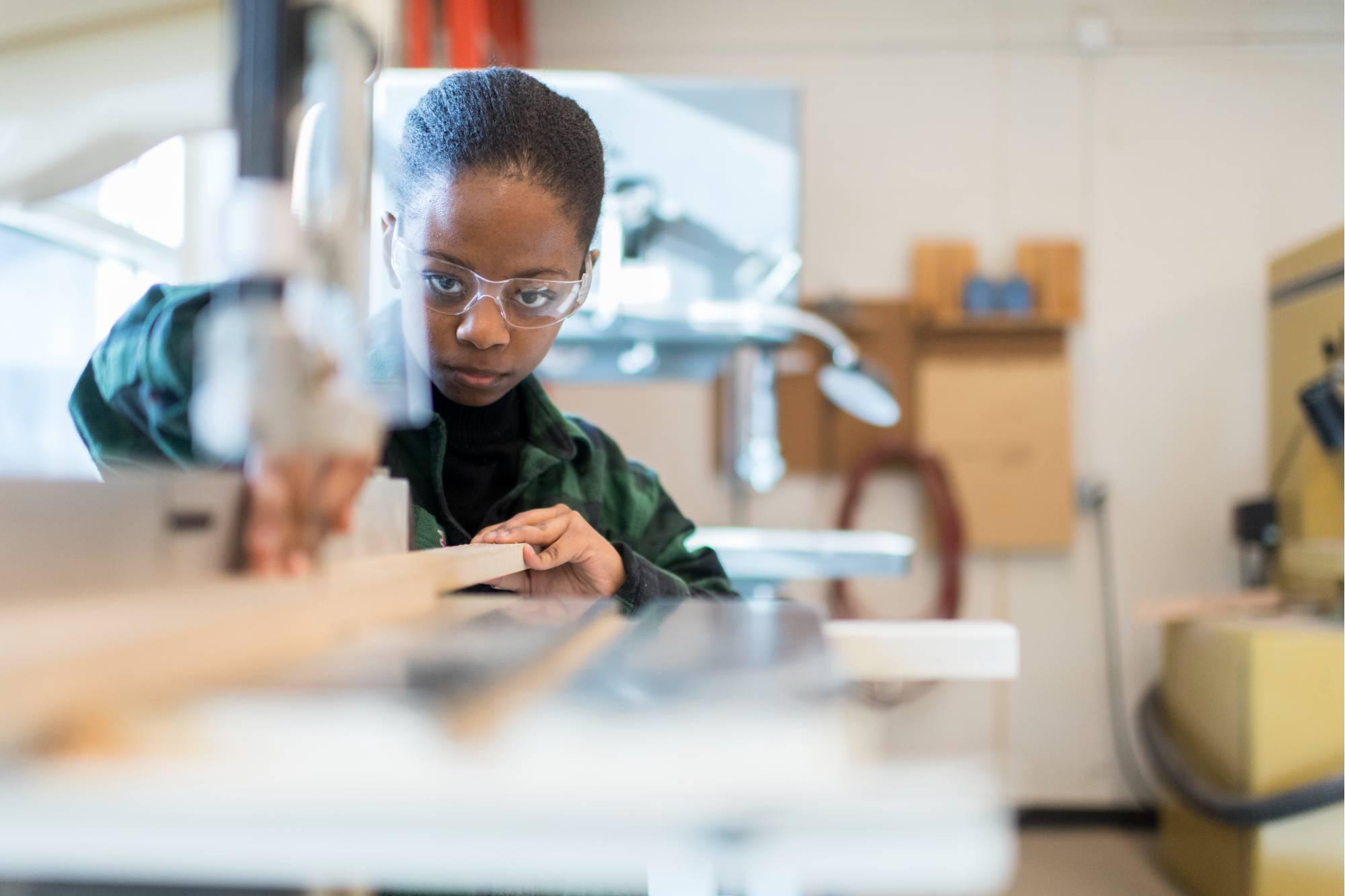 A students working on the band saw with concentration - focus